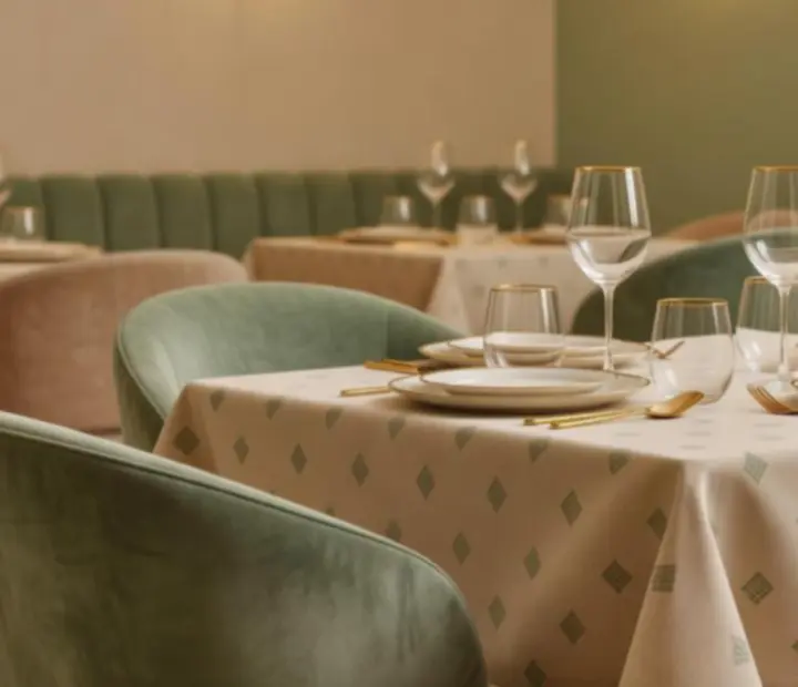 Interiér restaurace Tajný Salon s prostřenými stoly a jemným nasvícením